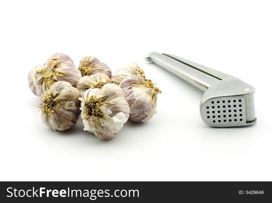 Raw garlic and garlic press, isolated