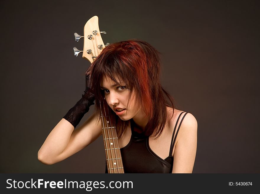 Sensual girl with bass guitar isolated in studio