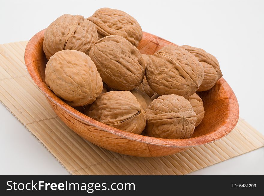 Walnuts in a bowl, on white background.