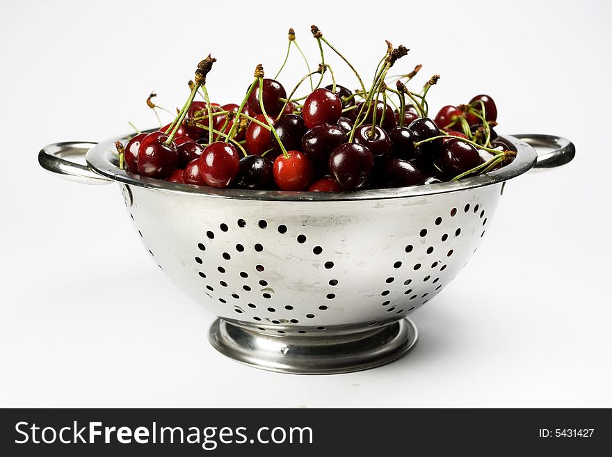 Fresh cherry in Colander on white background