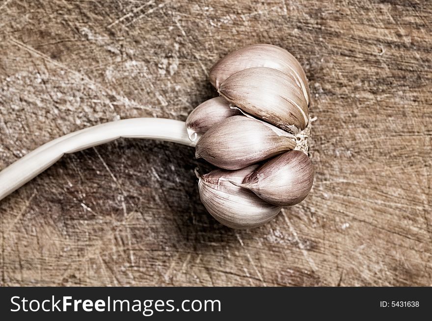 Garlic on a wooden cutting table, close up. Garlic on a wooden cutting table, close up.