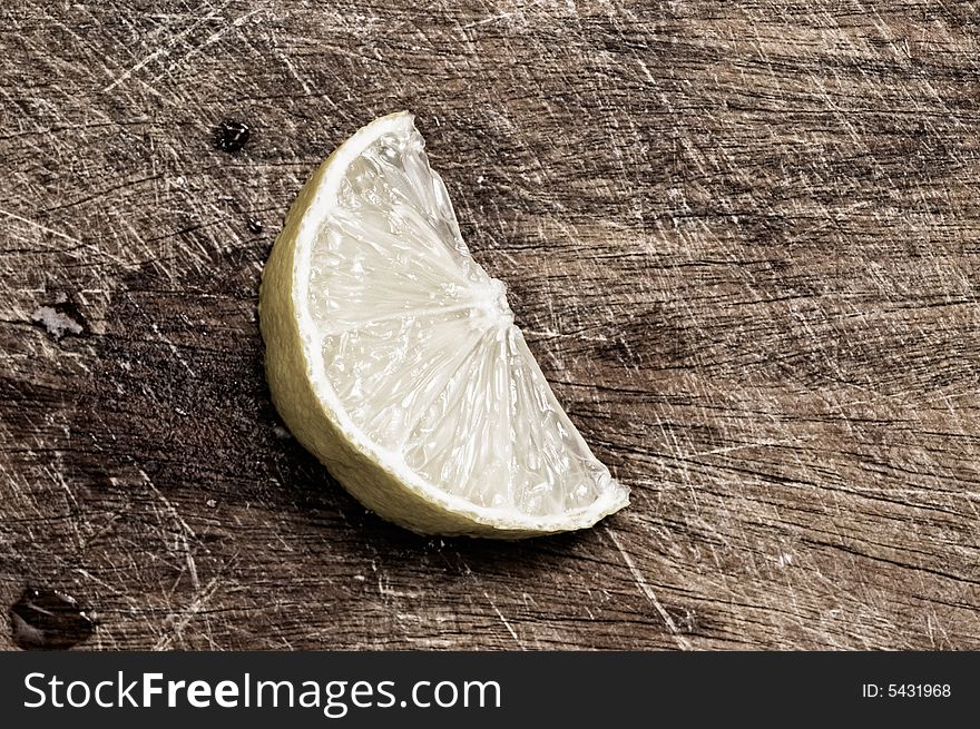 Half lemon ona wooden table, close up. Half lemon ona wooden table, close up.