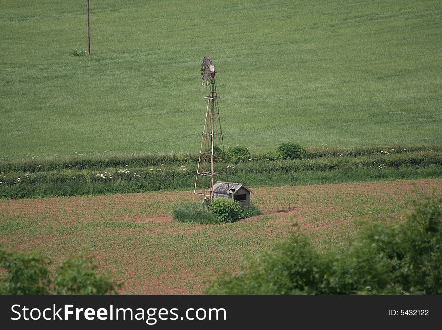An abandoned windmill sits idle in a field. An abandoned windmill sits idle in a field