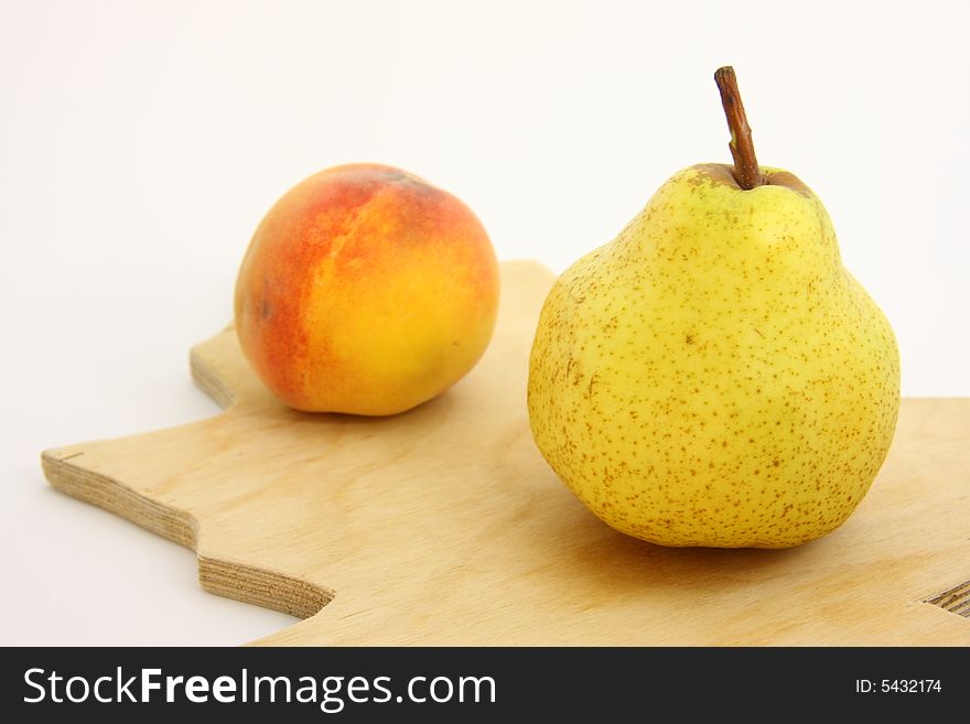 Pear and peach on woody kitchen board