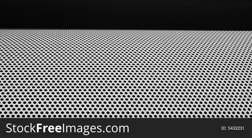Graphic design detail of a grid in aluminum on a building surface