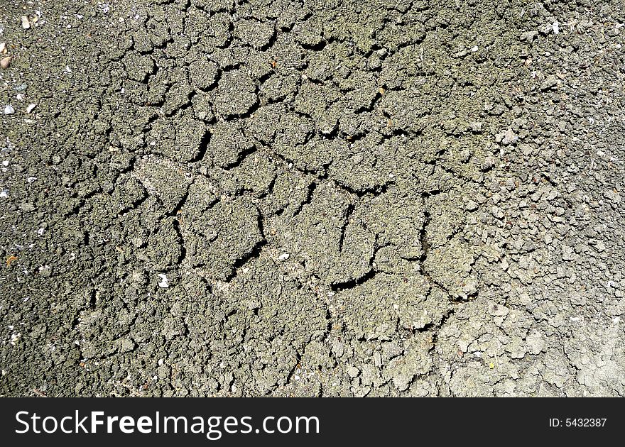 An photograph of some cracks on the surface of some mud. An photograph of some cracks on the surface of some mud.