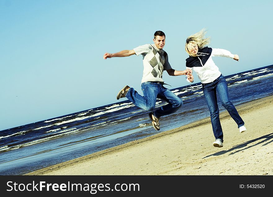 Young couple jumping on the beach. Young couple jumping on the beach.