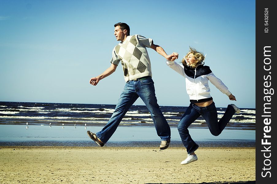 Young couple jumping on the beach. Young couple jumping on the beach.