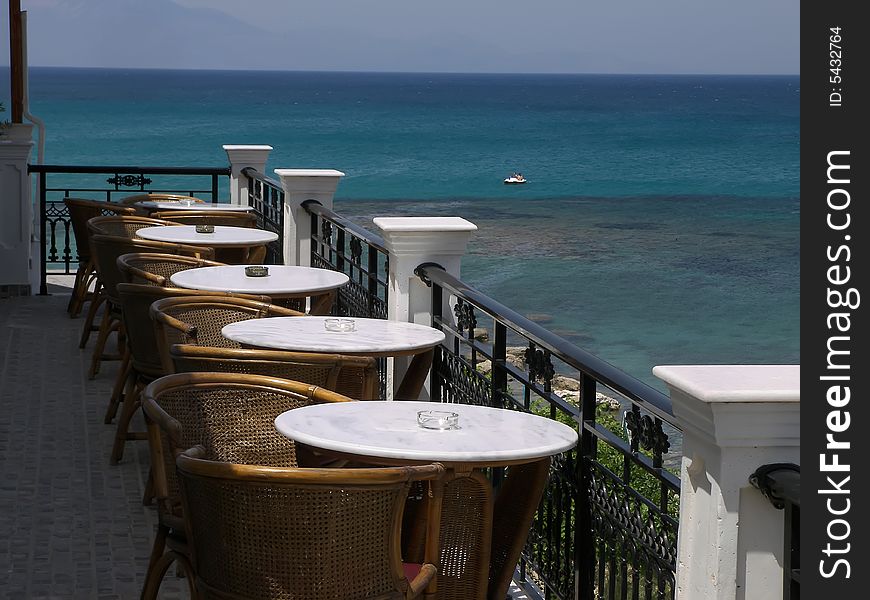 Hotel balcony overlooking a blue sea.