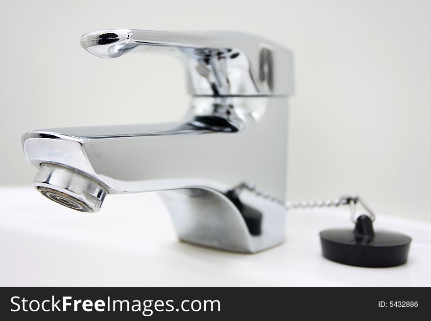 Chrome faucet on a sink, no running water. Chrome faucet on a sink, no running water