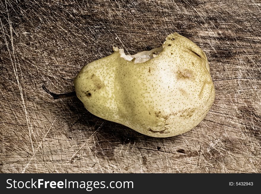 Bitten pear on wooden table.