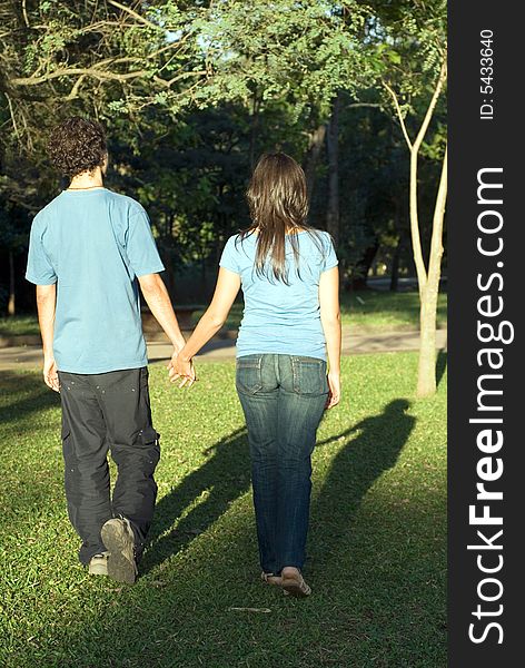 Young Couple Walking Through a Park - Vertical