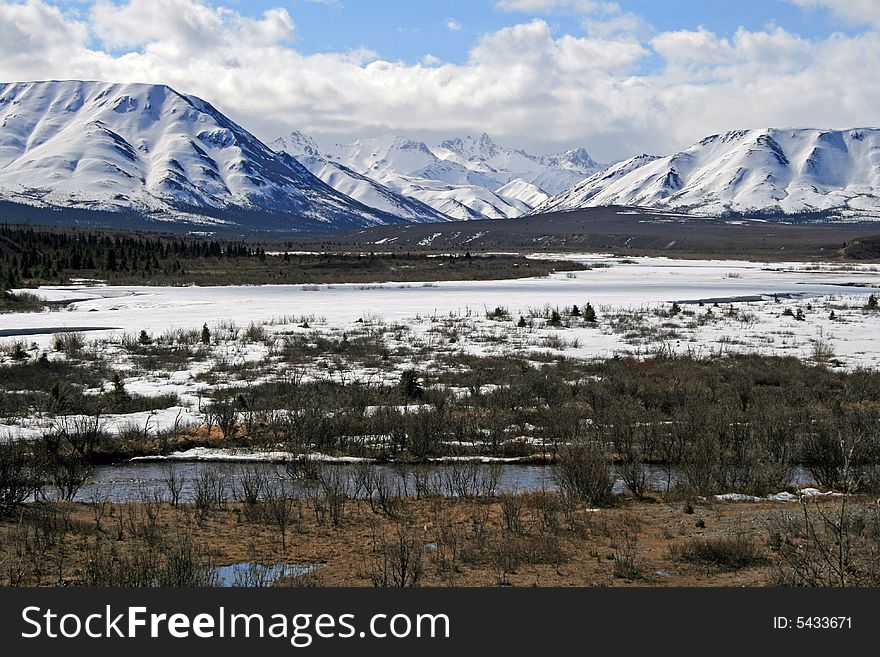 Snow covered mountains and a frozen pond in May. Snow covered mountains and a frozen pond in May.