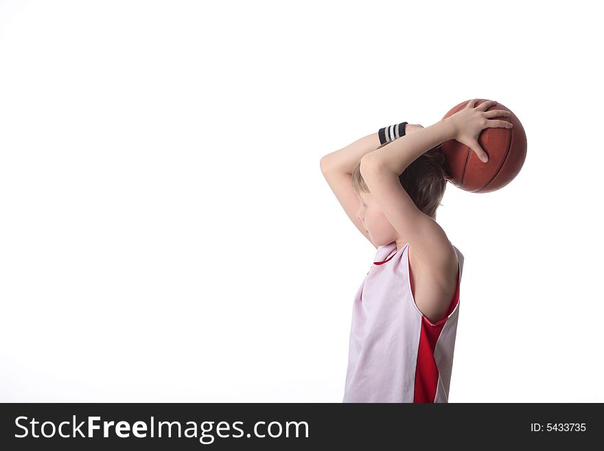 A 10 year old boy concentrating before a shooting a basketball. A 10 year old boy concentrating before a shooting a basketball