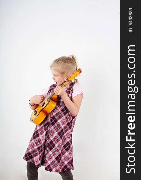 Small girl playing a toy guitar