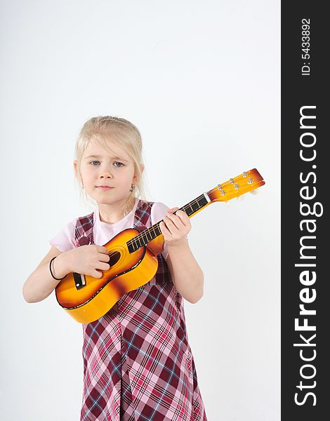 Small girl playing a toy guitar. Small girl playing a toy guitar