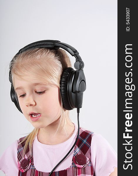 Small girl listening to music on headset. Small girl listening to music on headset