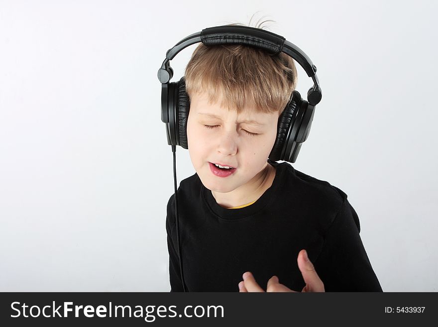 Young boy listening to music in headphones, very absorbed. Young boy listening to music in headphones, very absorbed
