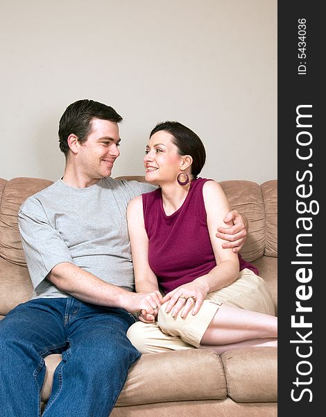 Happy Couple Hugging on a Couch - Vertical
