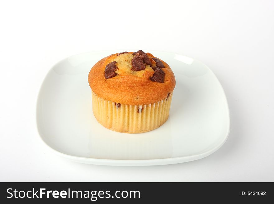 Cupcake on a white plate, isolated on white shot in studio. Cupcake on a white plate, isolated on white shot in studio