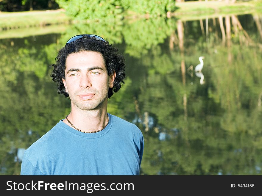 Man standing in front of a pond looking off into the distance. Man standing in front of a pond looking off into the distance