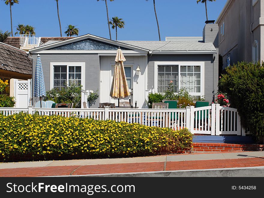 Quaint cottage with white fence at beach front. Quaint cottage with white fence at beach front
