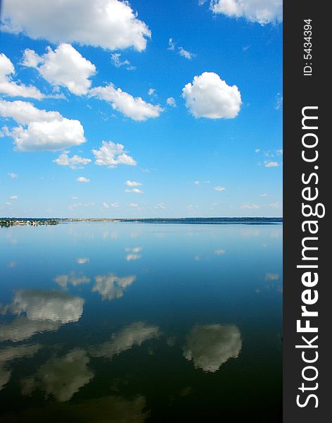 Cloudy blue sky reflection in calm water. Cloudy blue sky reflection in calm water