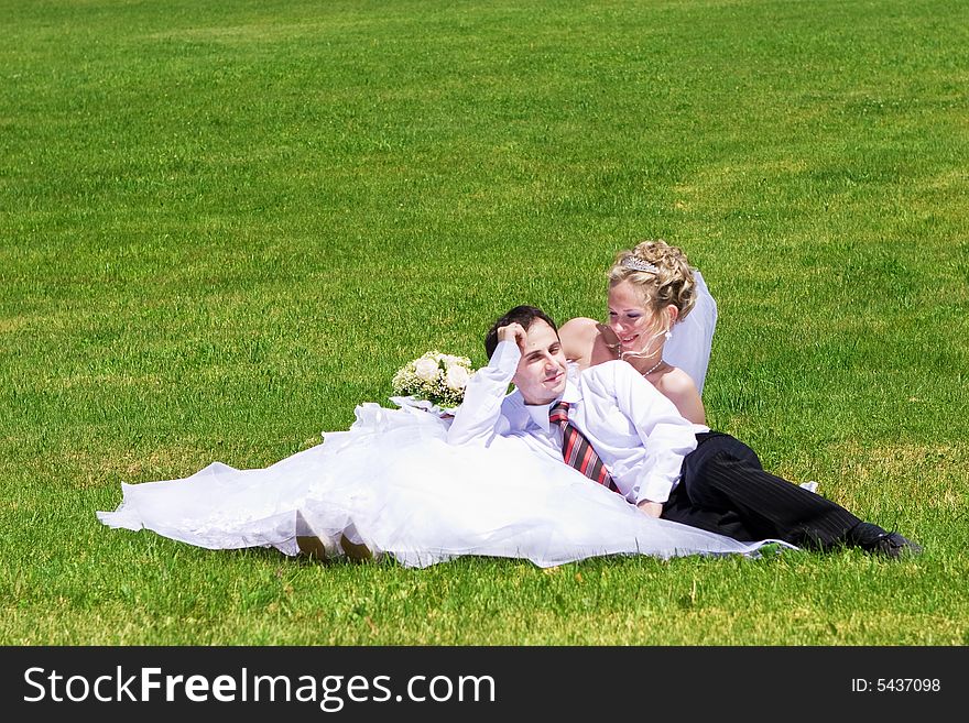 Rest of newly married couple on the grass. Rest of newly married couple on the grass