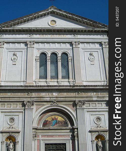 Portal of Catholic cathedral against clear blue sky in Italian village