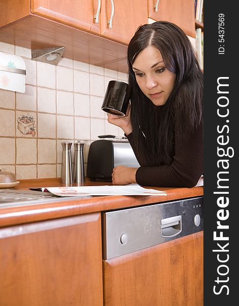 Attractive woman with coffee in kitchen