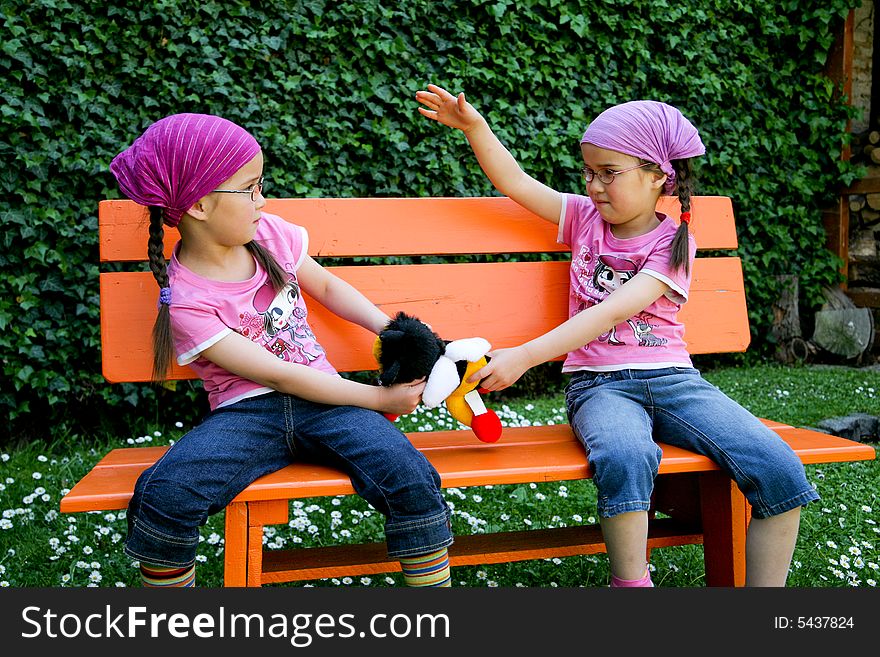 True twins with toy in the garden