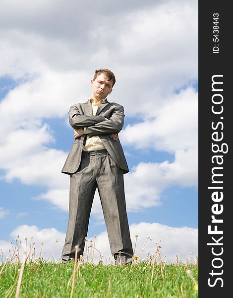 The young businessman standing on a green grass