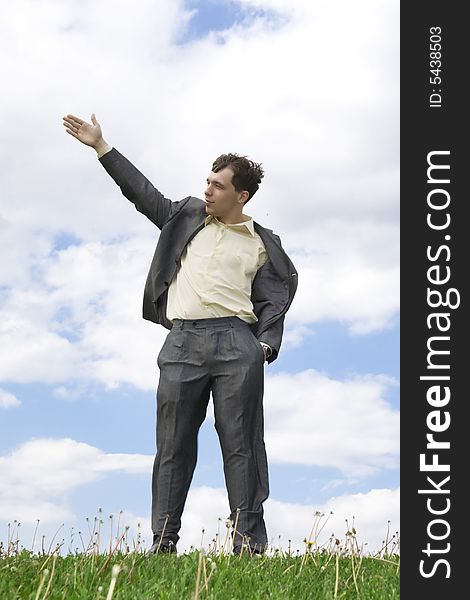 The young businessman standing on a green grass