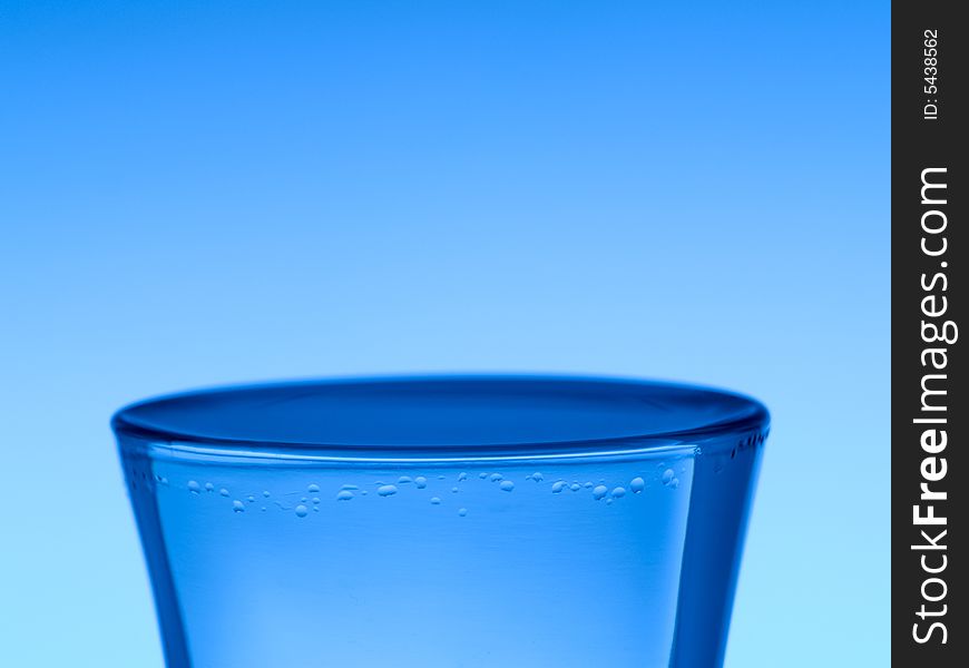 A shot of vodka on blue background.