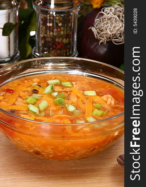 Bowl of Chicken Tortilla Soup garnished with shredded cheddar and green onions.