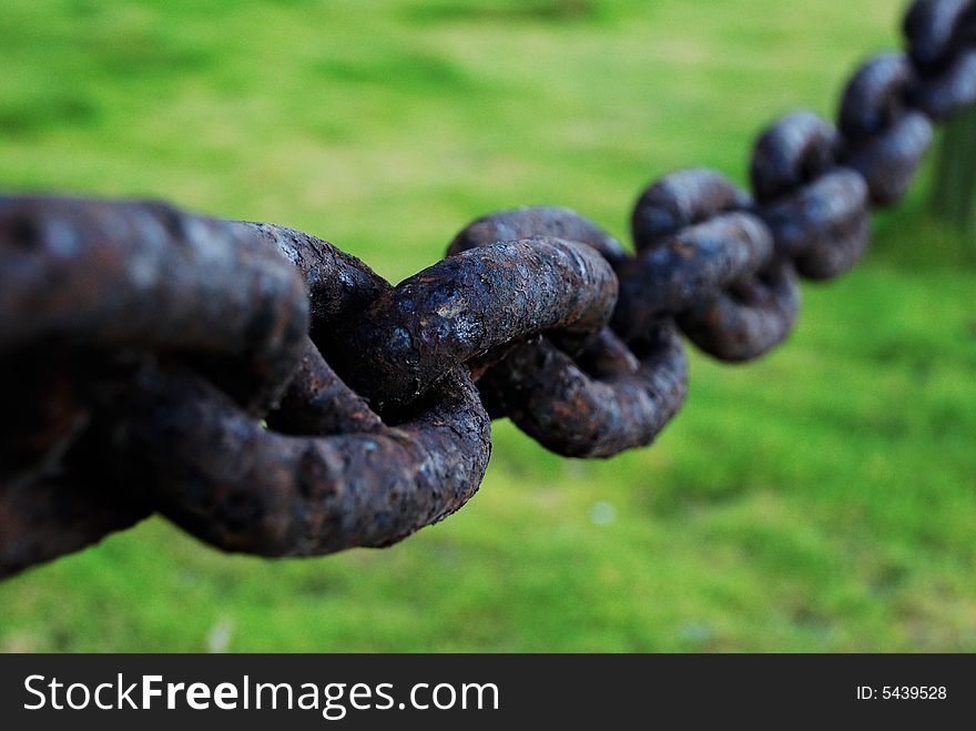 A massive, old chain rusted from exposure to the elements by the sea shore. A massive, old chain rusted from exposure to the elements by the sea shore