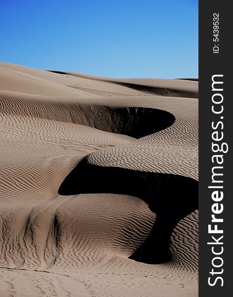 Shot of a sand dune that has been wind blown into a S shaped curve in the California desert. Shot of a sand dune that has been wind blown into a S shaped curve in the California desert