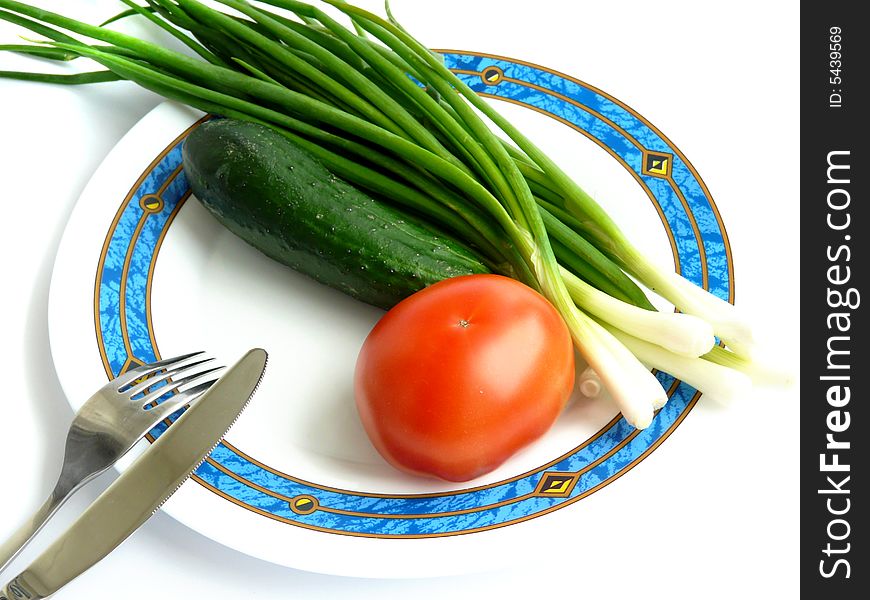 Green onion, cucumber and tomato on the plate. Green onion, cucumber and tomato on the plate