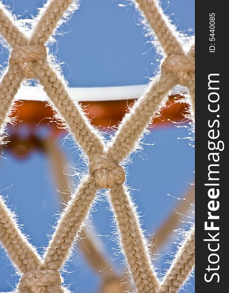 Close up of a basketball hoop and net, back lit by late morning sun and a clear blue sky. Close up of a basketball hoop and net, back lit by late morning sun and a clear blue sky.