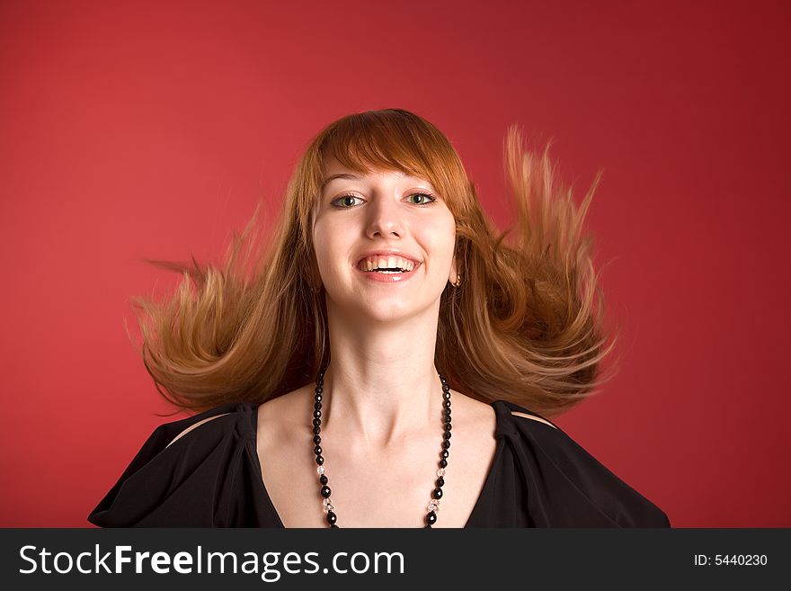 Beautiful red-haired girl isolated on red background. Beautiful red-haired girl isolated on red background