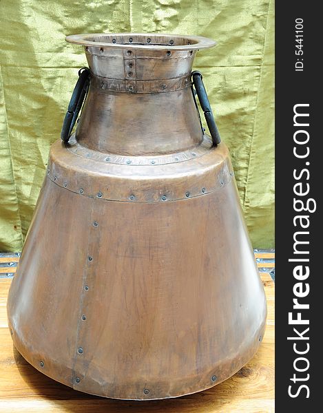 A beautifully restored antique copper pot or container, possibly used for storage of dry foods or water.