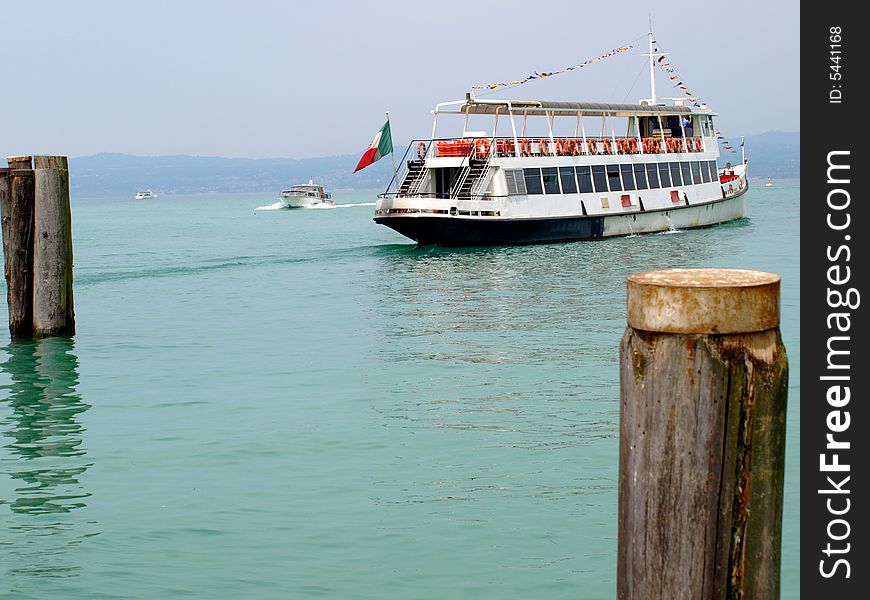 A beautifull shot of a ferry-boat that's leaving the port on a lake. A beautifull shot of a ferry-boat that's leaving the port on a lake