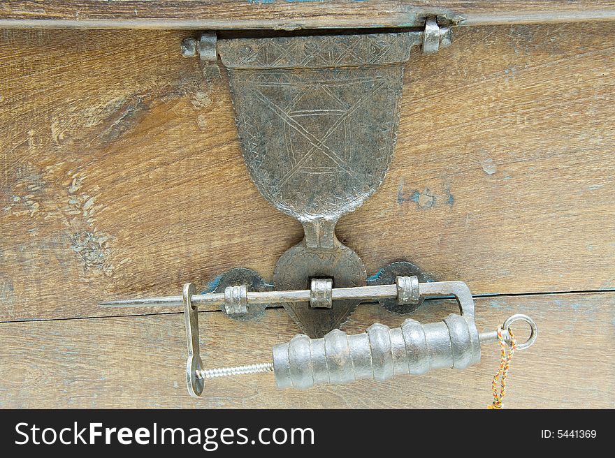 Antique locking mechanism or padlock on a restored antique chest with a hinged bracket lock.