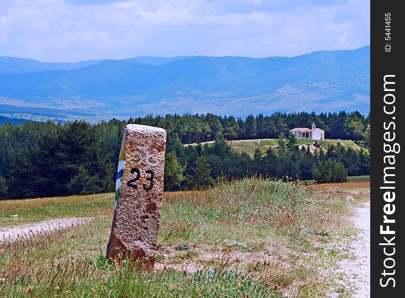 Column near the road and church far away.
Photo taken in Bulgaria in May 2008