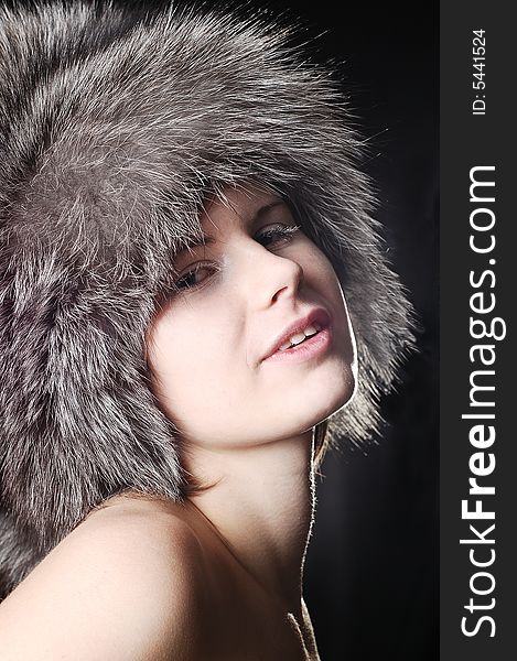 Smiling girl with white eyelashes wearing a fur winter hat. Smiling girl with white eyelashes wearing a fur winter hat