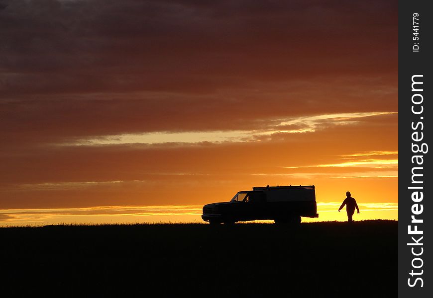 Old vehicle in silhouette at sunset in a field. Old vehicle in silhouette at sunset in a field