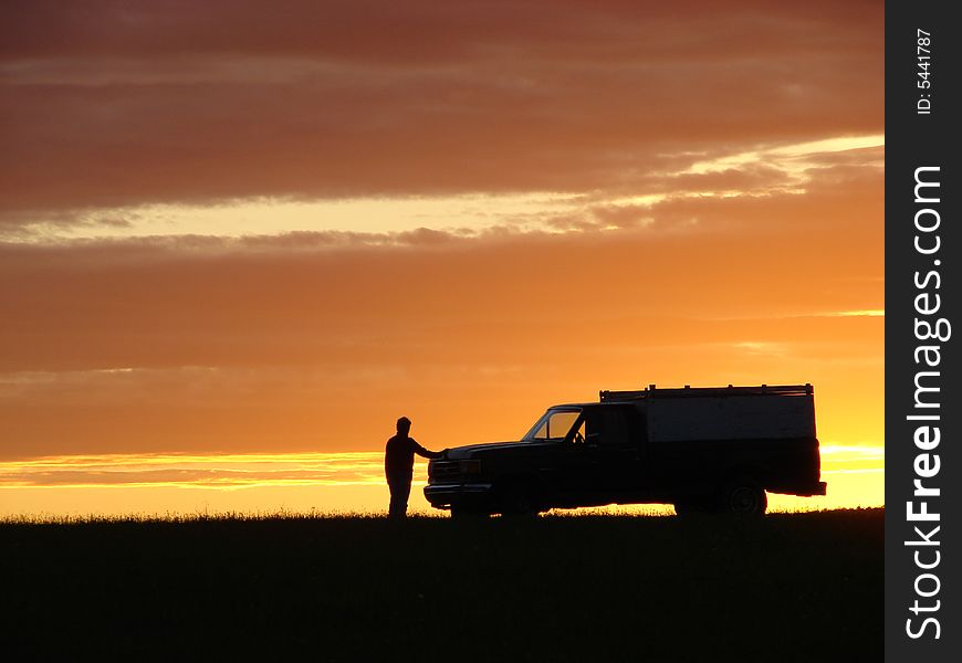 Old vehicle in silhouette at sunset in a field. Old vehicle in silhouette at sunset in a field