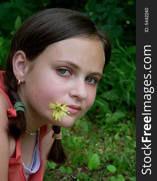 Teenage girl with braids and a yellow flower in her mouth. Teenage girl with braids and a yellow flower in her mouth
