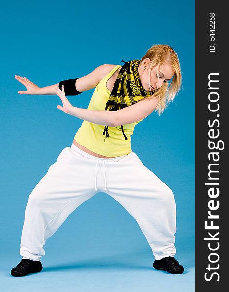 Attractive blond girl is dancing on a blue background. Attractive blond girl is dancing on a blue background