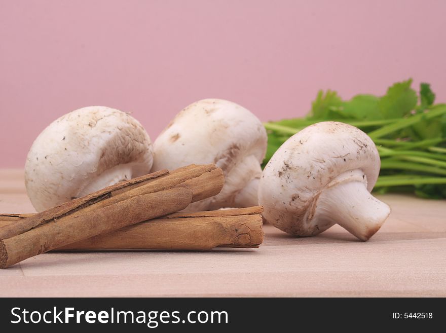 Mushrooms and Cinnamon With cilantro on Table with Pink Background